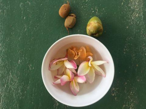Geschenke der Mä​dels: Blü​ten, eine junge Kokosnuss und essbare Frü​chte