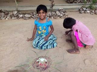 Dinithi und Aruni machen Sandkunst.