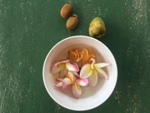 Geschenke der M&auml;​dels: Bl&uuml;​ten, eine junge Kokosnuss und essbare Fr&uuml;​chte