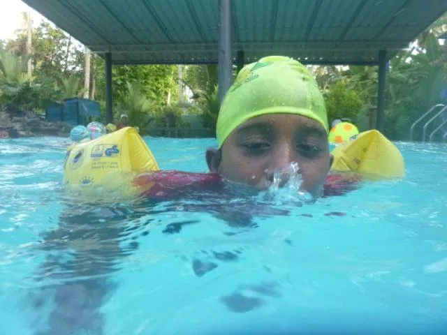 Man sieht das M&auml;dchen Vindiya, die mit ihrem Mund im Wasser blubbert
