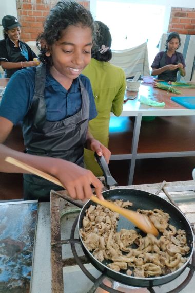 Thilini beim anbraten von Pilzen